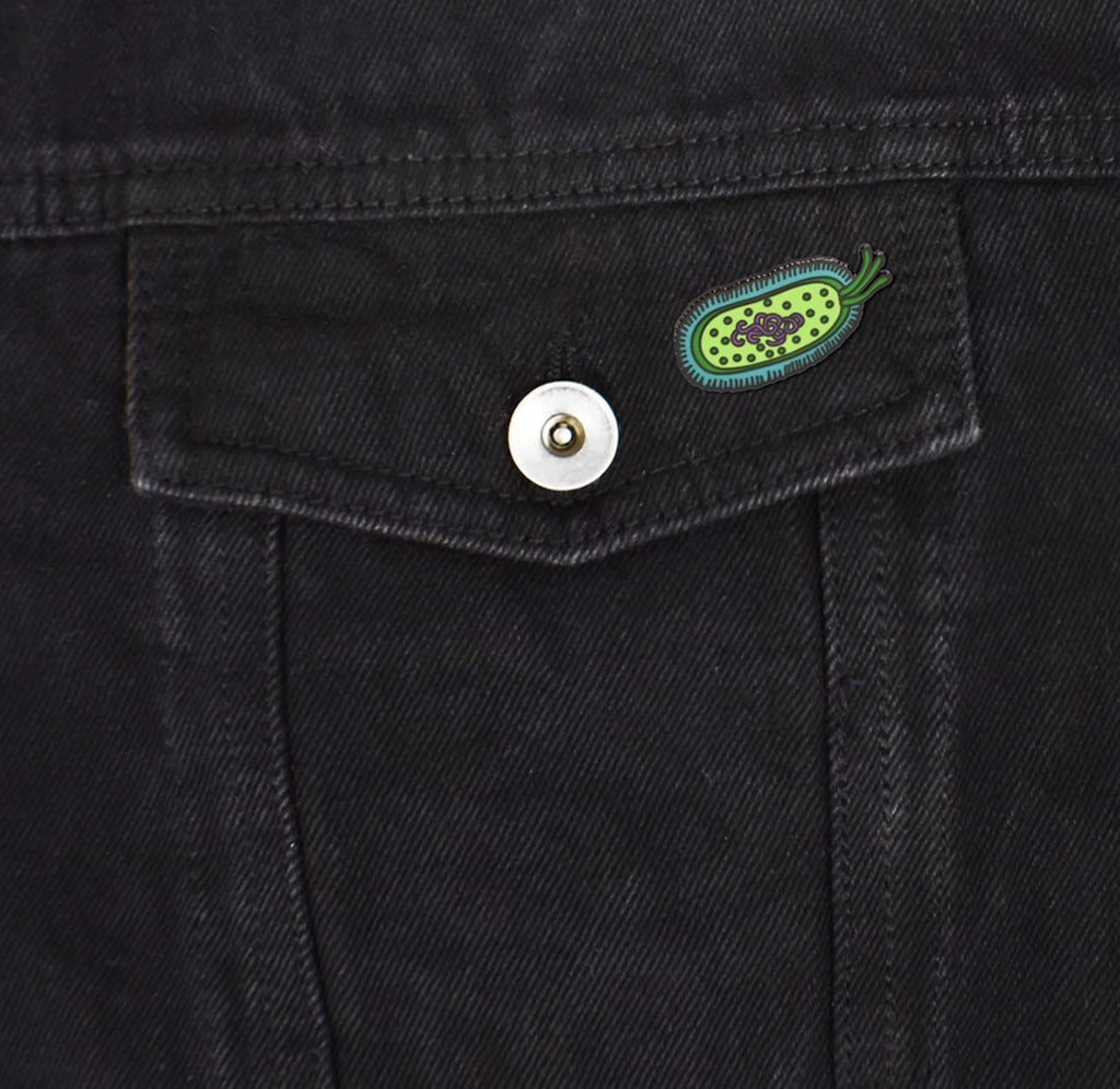 The bacteria pin is fastened to a black denim pocket. 