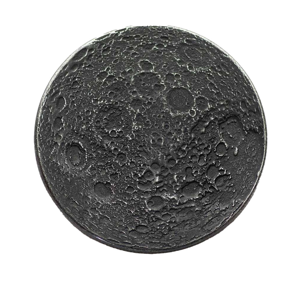 A round iron-colored coin that looks like a crater-filled side of the moon. 