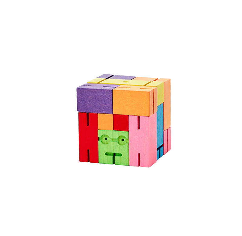 A cube constructed of multicolor pieces. There is a green square with a face-like carving. 