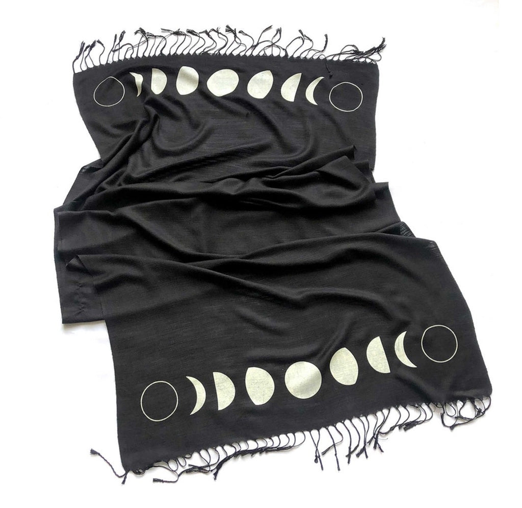 Black scarf with fringe and white prints of various moon phases on either end. 