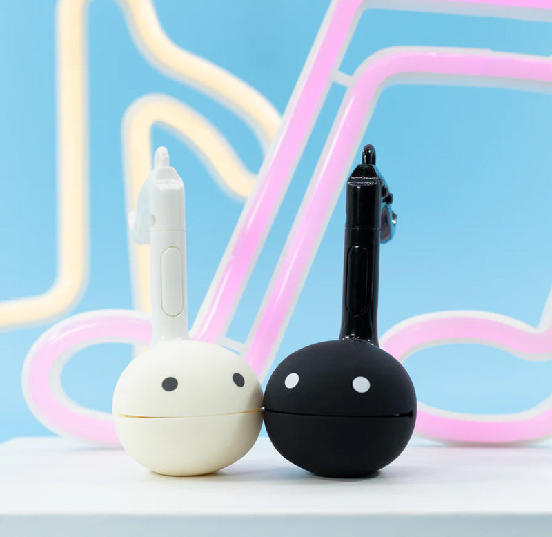 A black and a white music note shaped toy sitting on a table. 