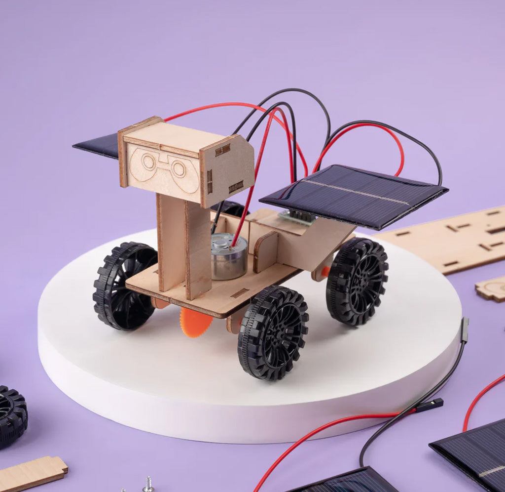 A wooden rover with black plastic wheels and two solar panels wired in the back. 