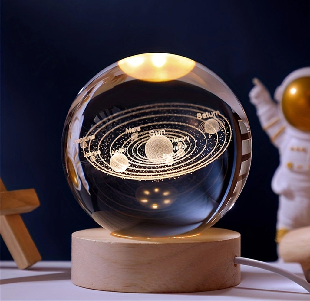 A glass ball with the solar system depicted inside. There is a wooden base with a wire attached to the side.