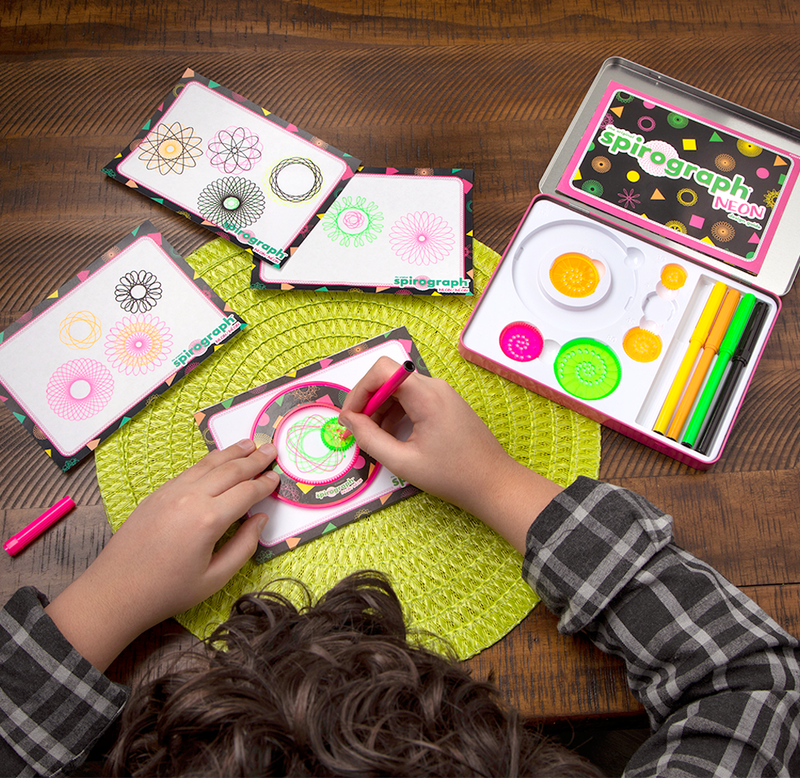 A child drawing patterns using a pink marker and a lime green circular template inside of a larger ring. 